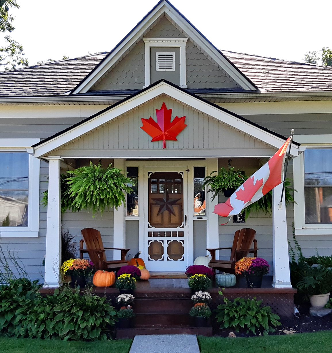 The front porch of a suburban home in Canada with fall decorations