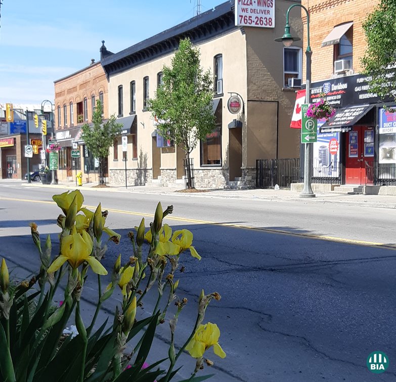 A view of a town street with storefronts in old fashioned buildings